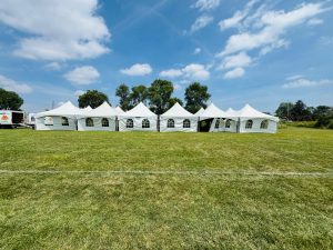 A long row of connected white party tents for a large event rental at Crusaders Rugby Club in Oakville, Ontario.